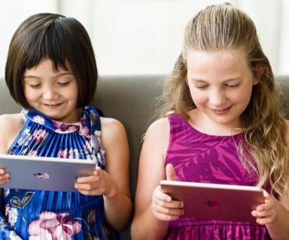Two girls learning using tablets