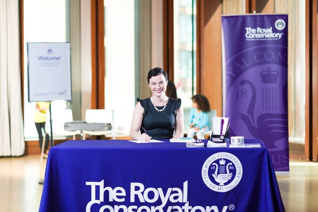 woman sitting behind The Royal Conservatory desk