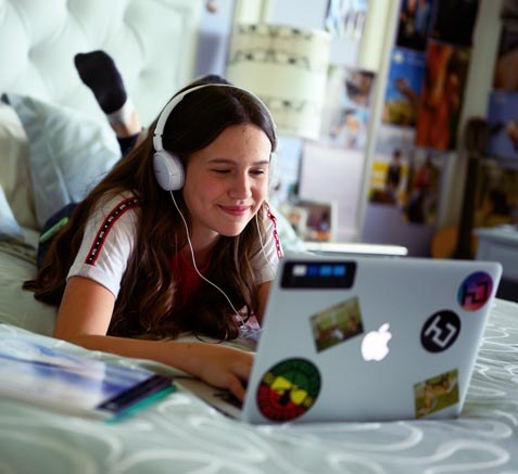 teen watching and listening to something on their laptop