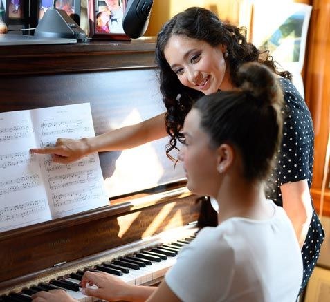 Piano instructor teaching student to read notes