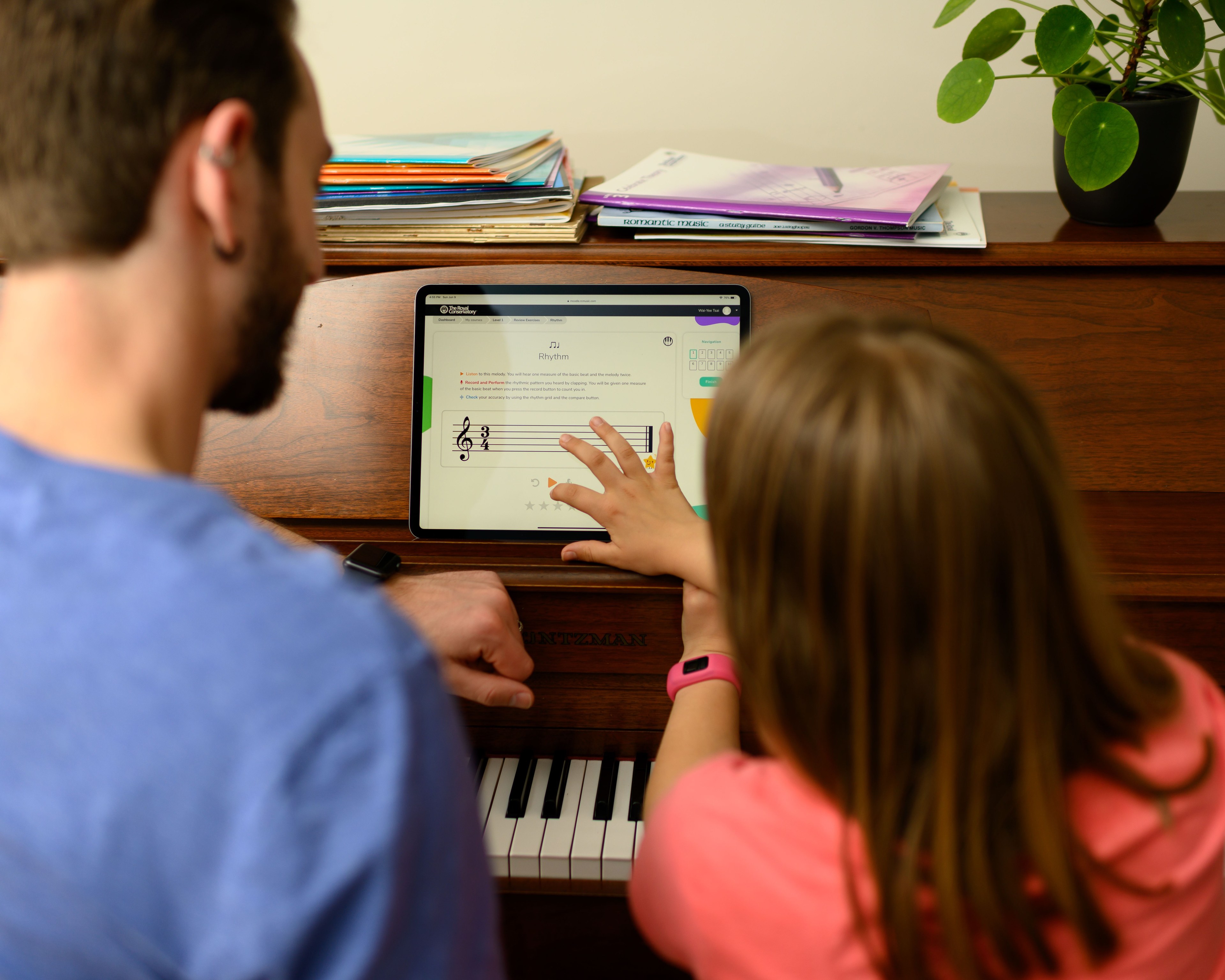 man and child looking at tablet on the piano