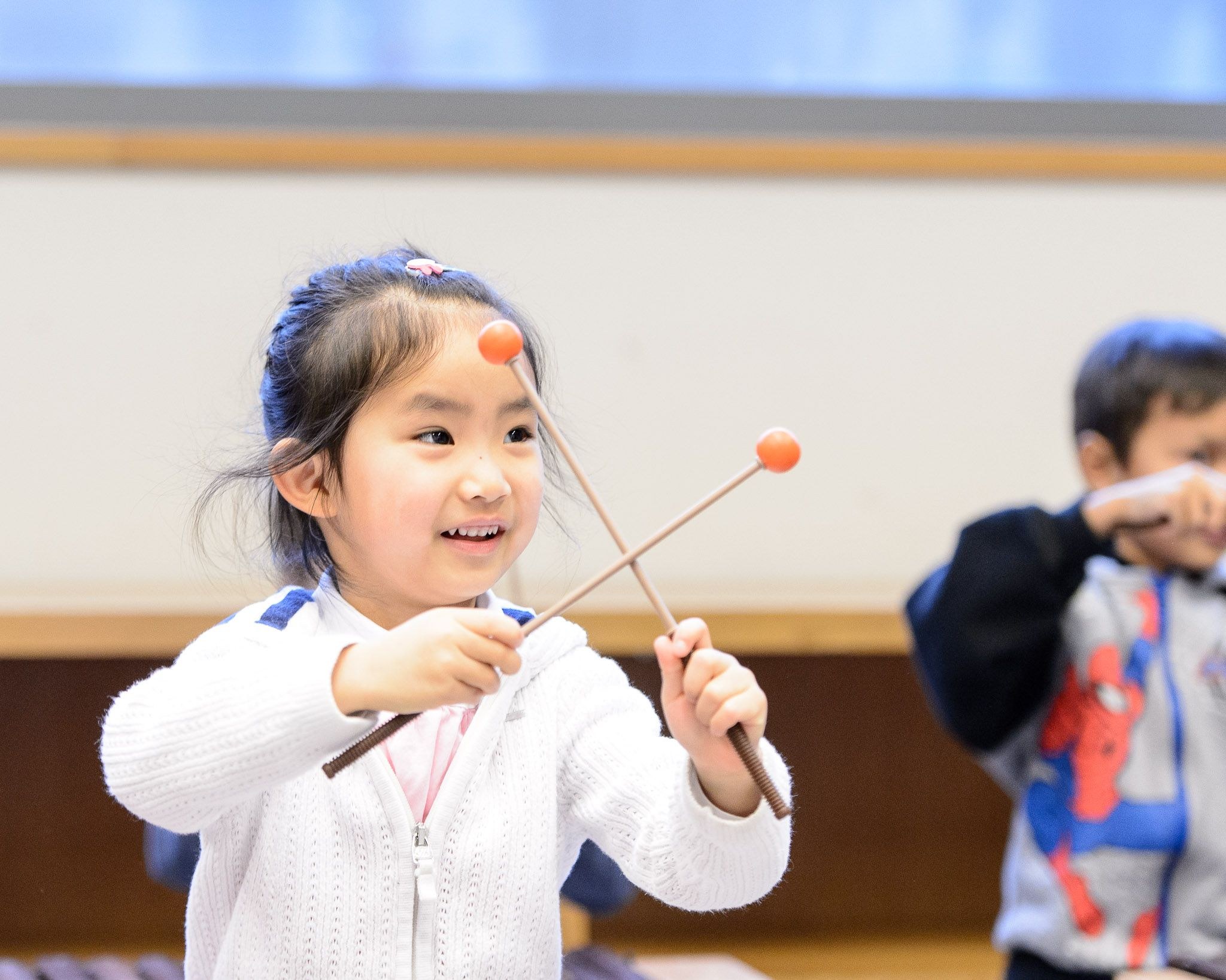 child holding drum sticks