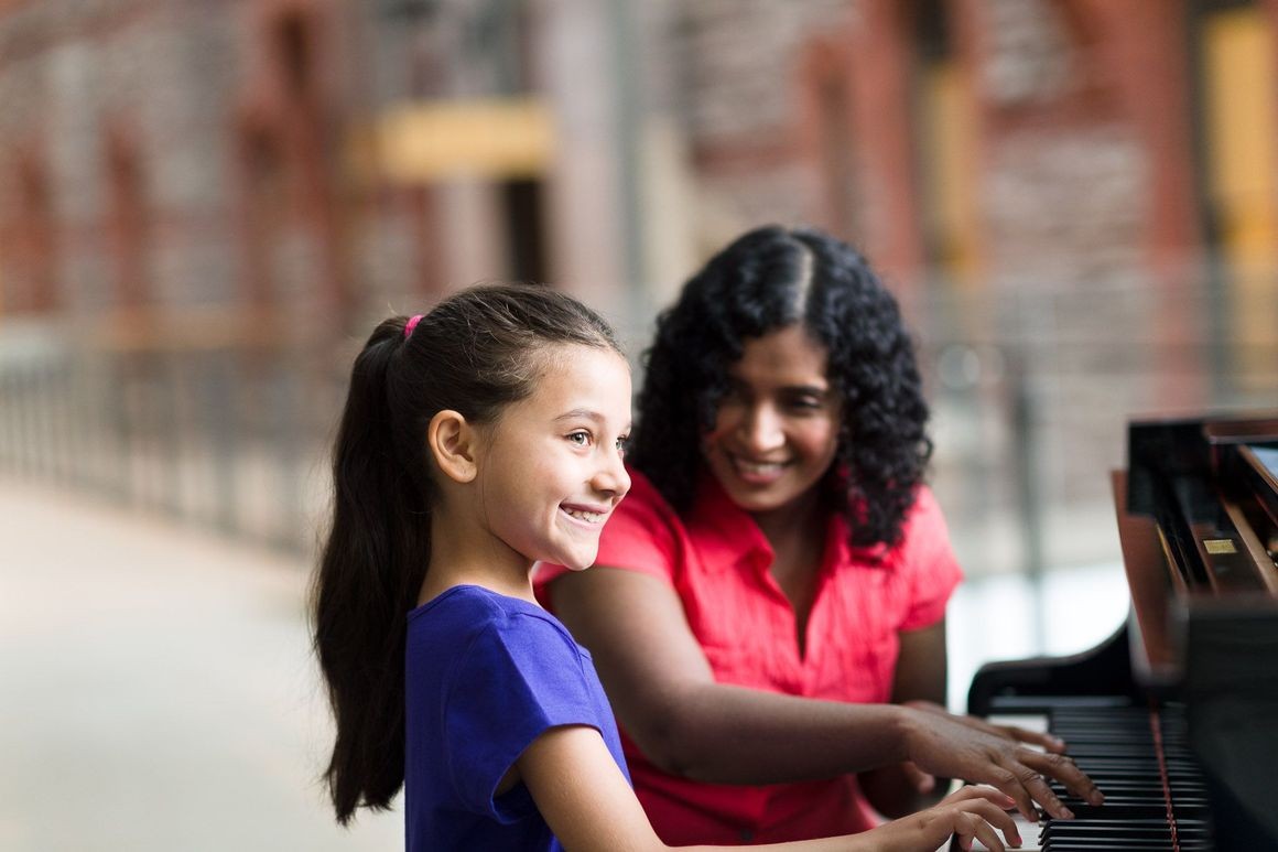 Teacher and student playing piano